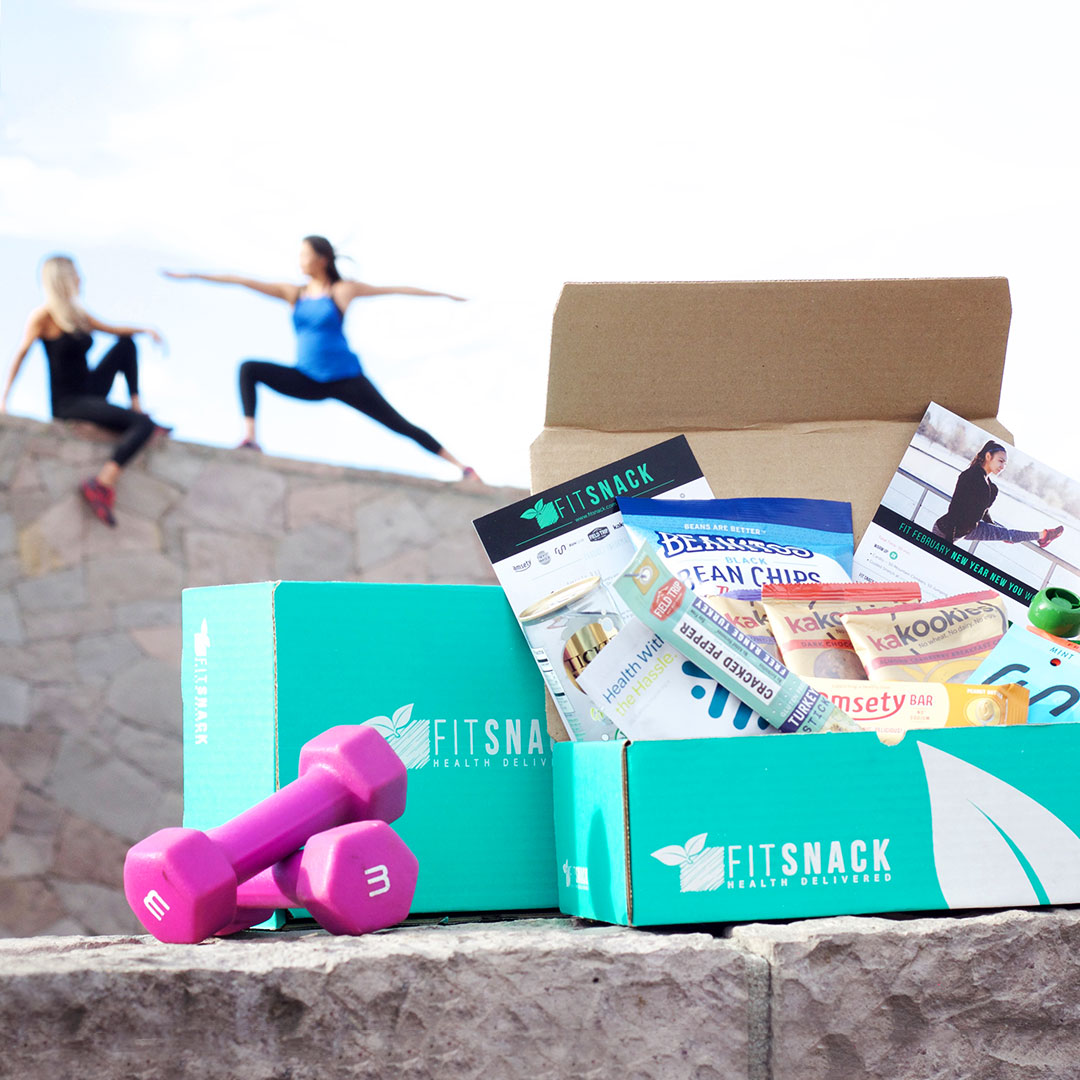Image of Fit Snack box for February 2017. Shows products, weights and people working out in background.
